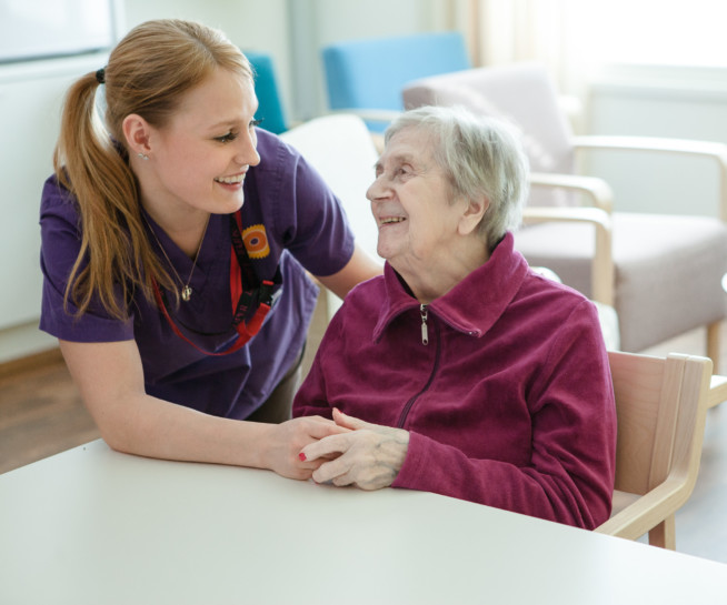 Nurse and elderly woman at the table.